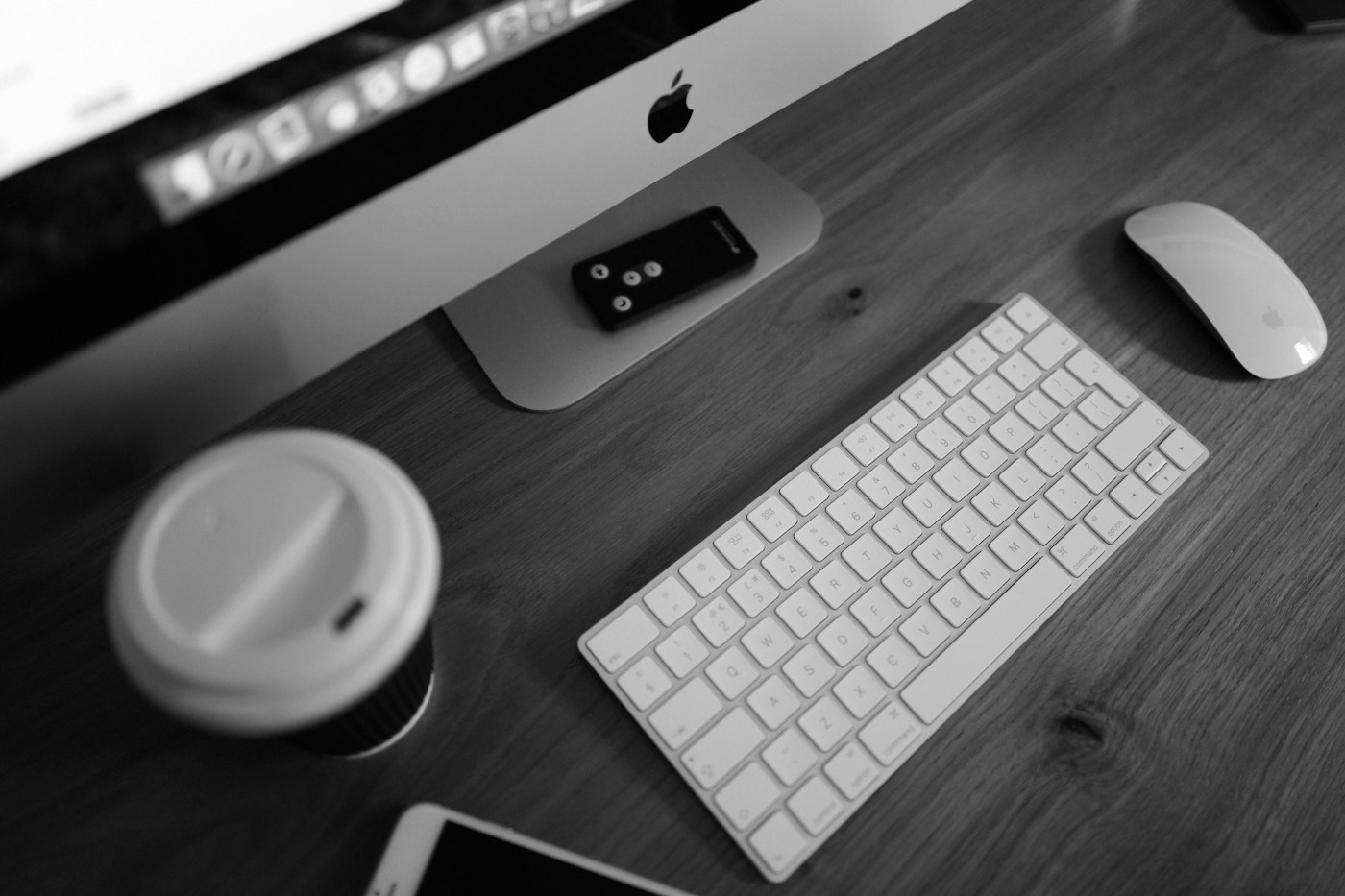 Schwarz-Weiß-Aufnahme eines Schreibtischs mit Computer und Tastatur